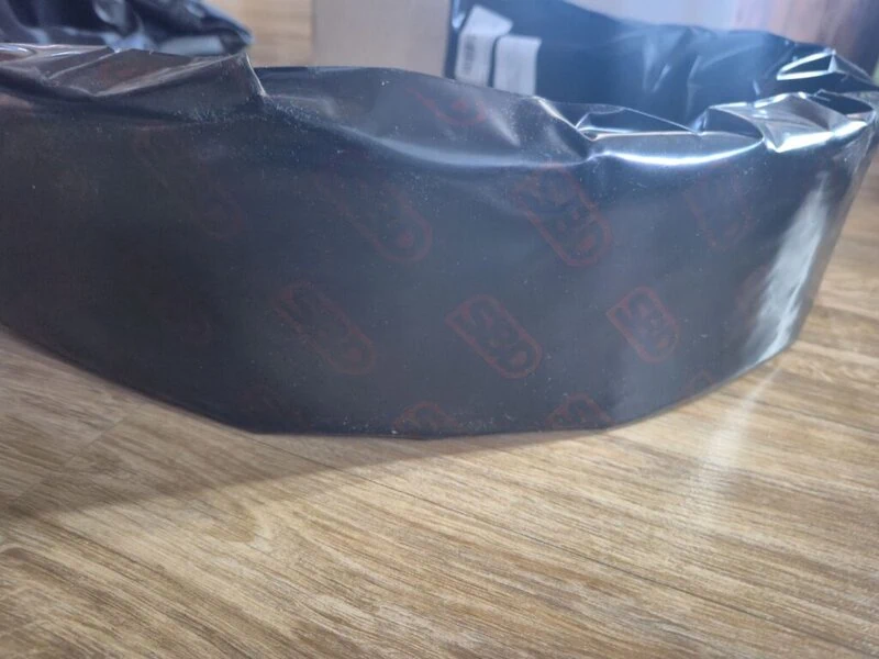 SBDベルトが「SBD」ロゴ入りの黒い包装紙に包まれている。