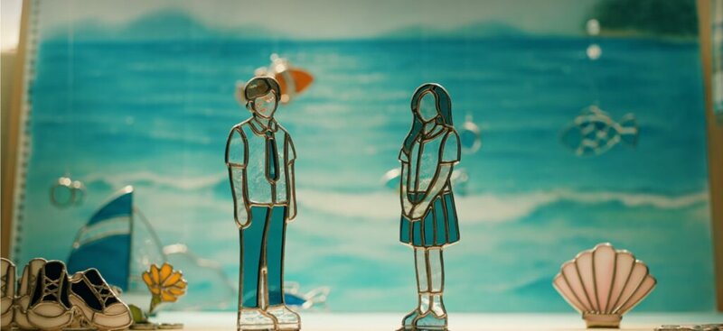 바다 배경에 서 있는 스테인드글라스 남녀 학생 피규어