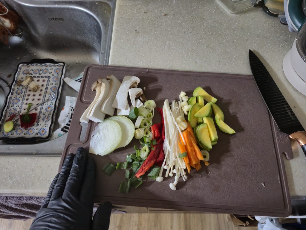 Memotong sayuran segar seperti jamur, bawang bombay, wortel, dan zucchini